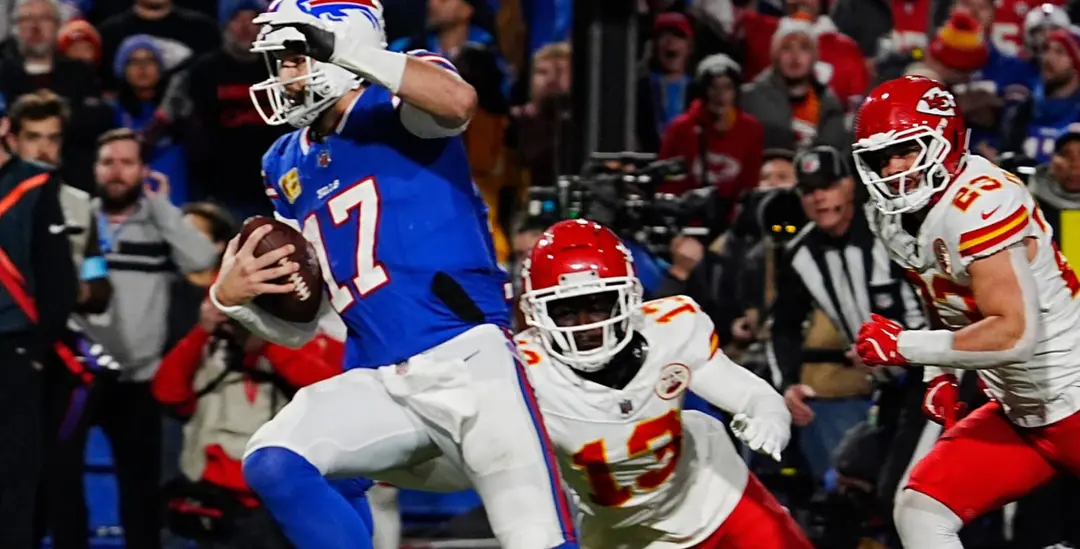 Buffalo Bills quarterback scrambles as Kansas City Chiefs defenders pursue in NFL matchup.