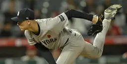 New York Yankees pitcher in action delivering a pitch during MLB game.