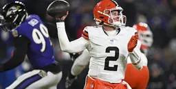 Cleveland Browns quarterback under pressure from Baltimore Ravens defender during NFL game