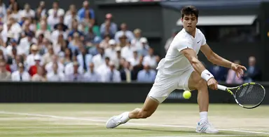 Tennis player hitting a low forehand shot on grass during the Wimbledon Championships