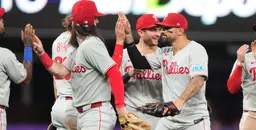 Philadelphia Phillies players celebrating on the field with high-fives after a victory