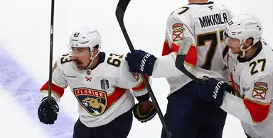 Florida Panthers players celebrate on ice after scoring in NHL game.