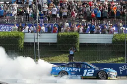 NASCAR driver performing a burnout in the No. 12 Wabash car in front of cheering fans at the Pocono Raceway during the Great American Getaway 400