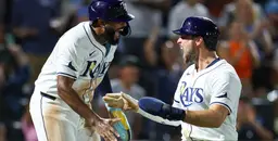 Tampa Bay Rays players celebrating passionately on the field after scoring