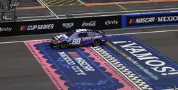 NASCAR race car number 88 crossing the colorful finish line at the Mexico City track during the NASCAR Cup Series event