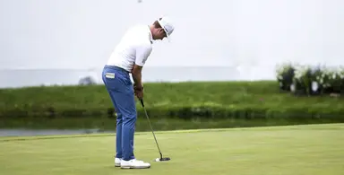 Ben Griffin putting on the green during a golf tournament